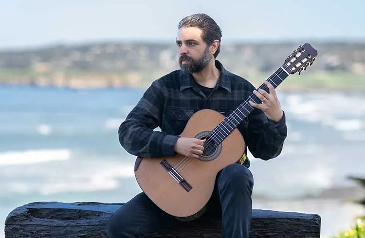 Chris Mallet playing acoustic guitar