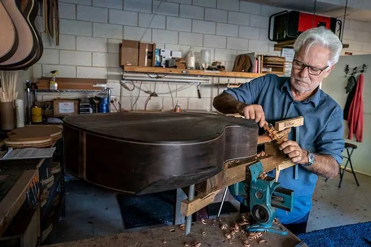 Luthier Kenny Hill works on an acoustic guitar neck