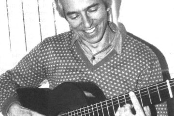 classical guitarist john williams holding guitar