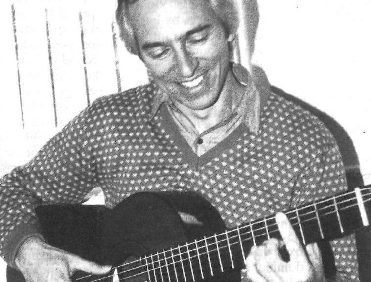classical guitarist john williams holding guitar