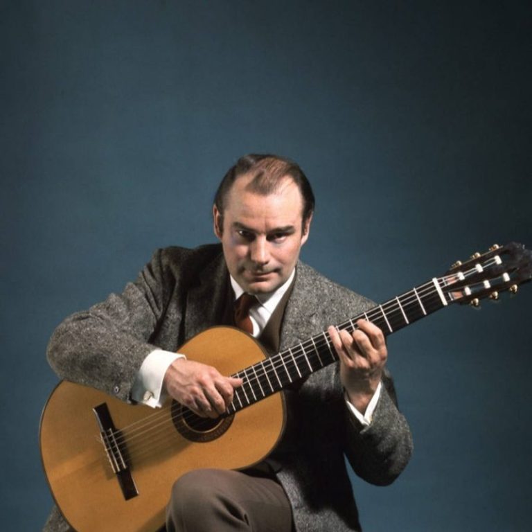 classical guitarist julian bream playing guitar looking at camera