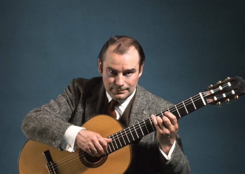 classical guitarist julian bream playing guitar looking at camera