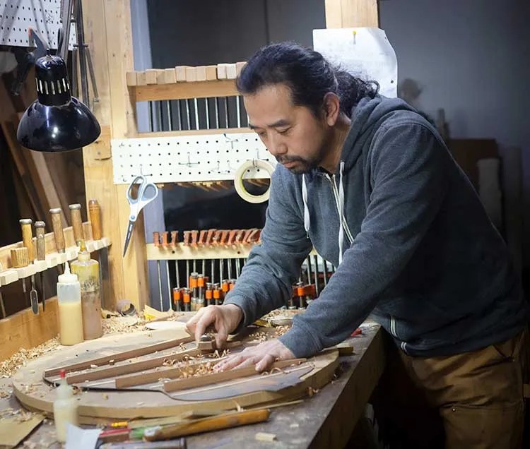 Luthier Michihiro Matsuda carves an acoustic guitar top piece